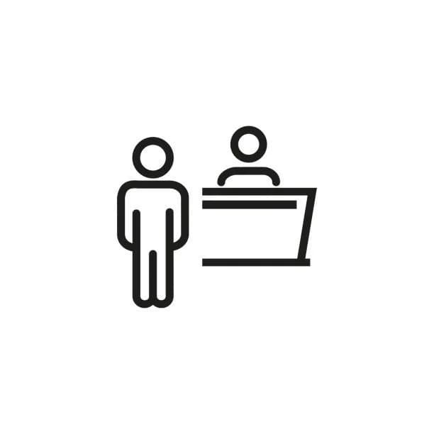 Icon of a person standing in front of a reception desk with a staff member behind it.
